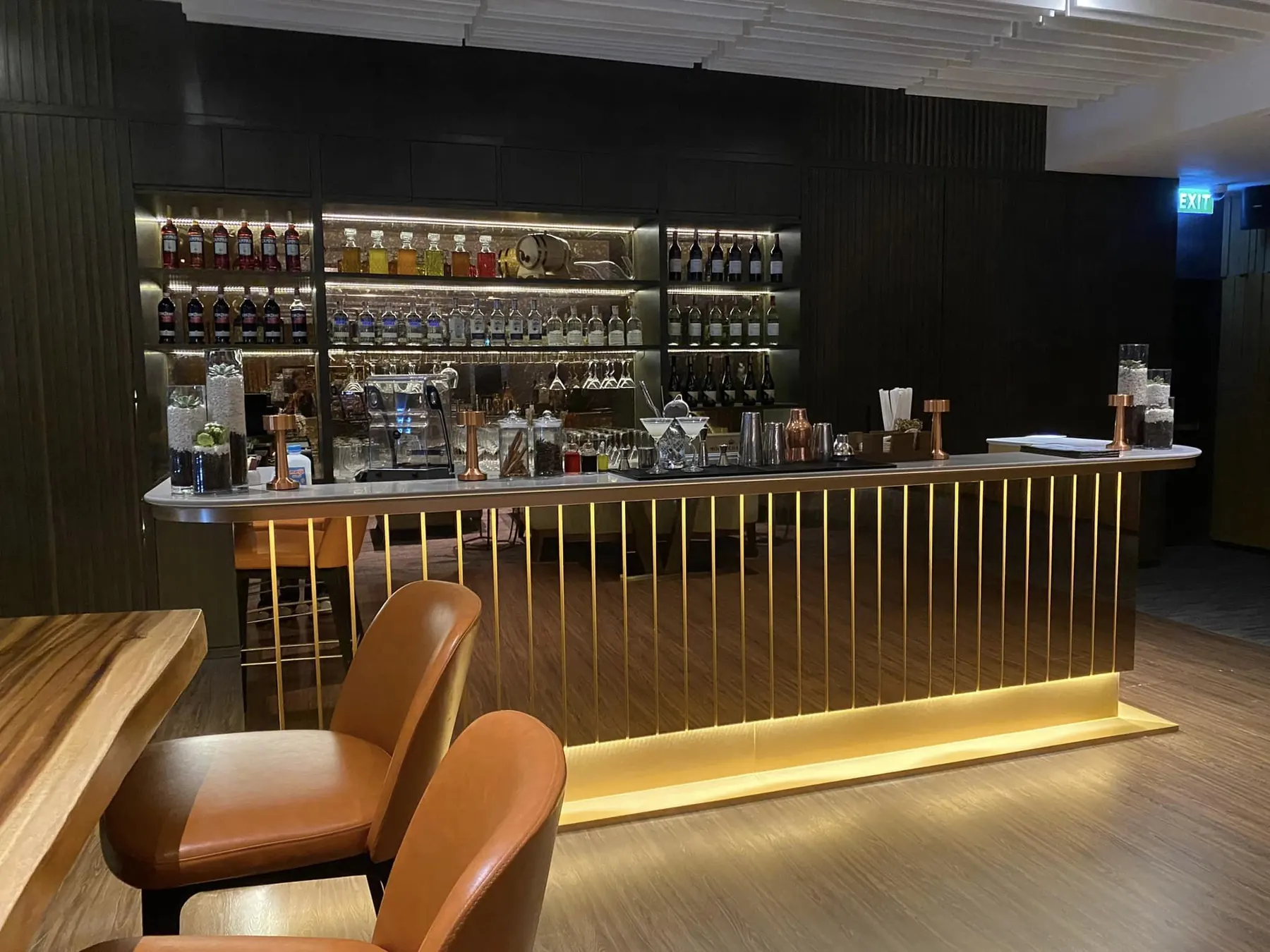 Executive Lounge: bar counter in brass rods with backlit bottle shelves