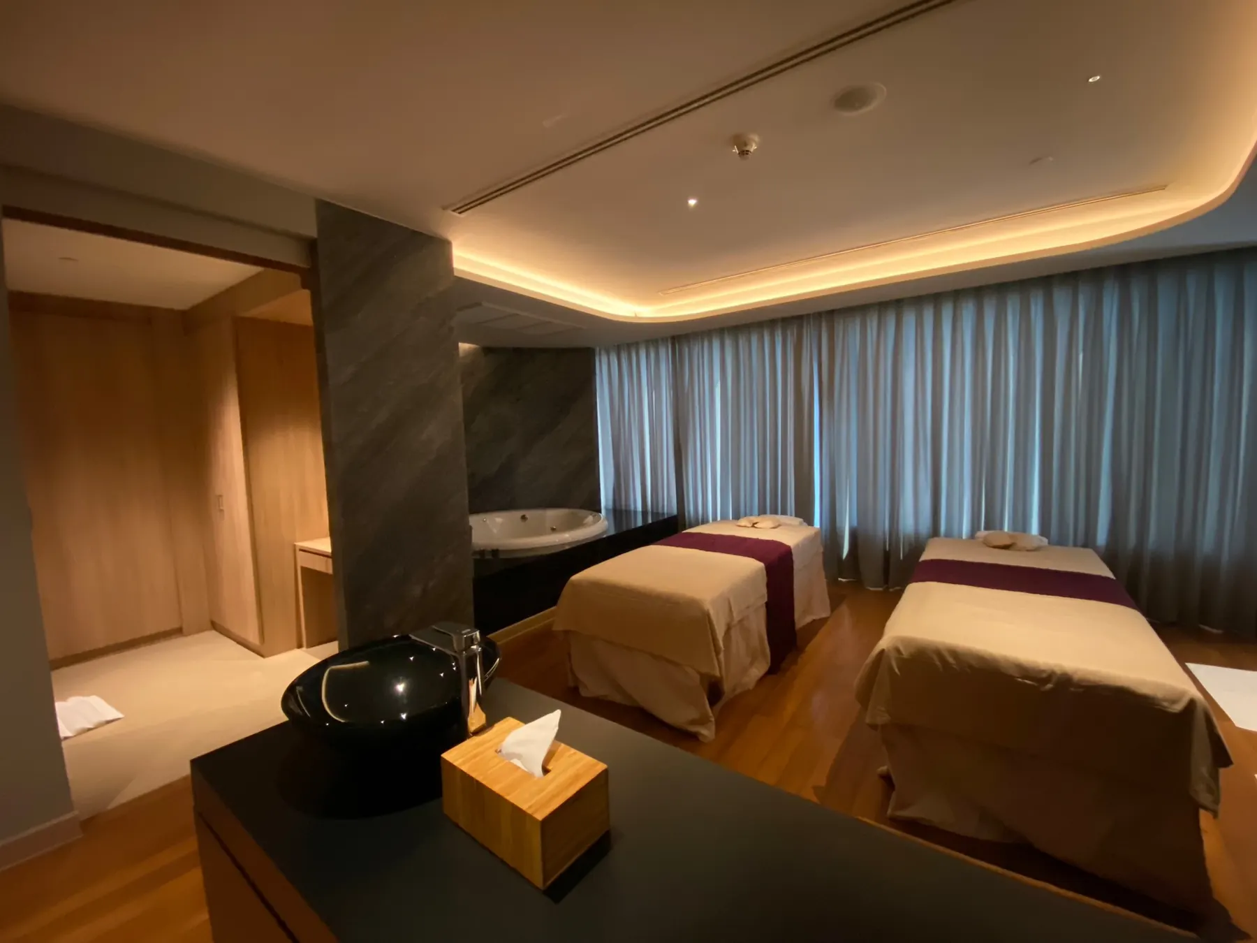 Maai Spa: a treatment suite with paired beds under a lit ceiling cove