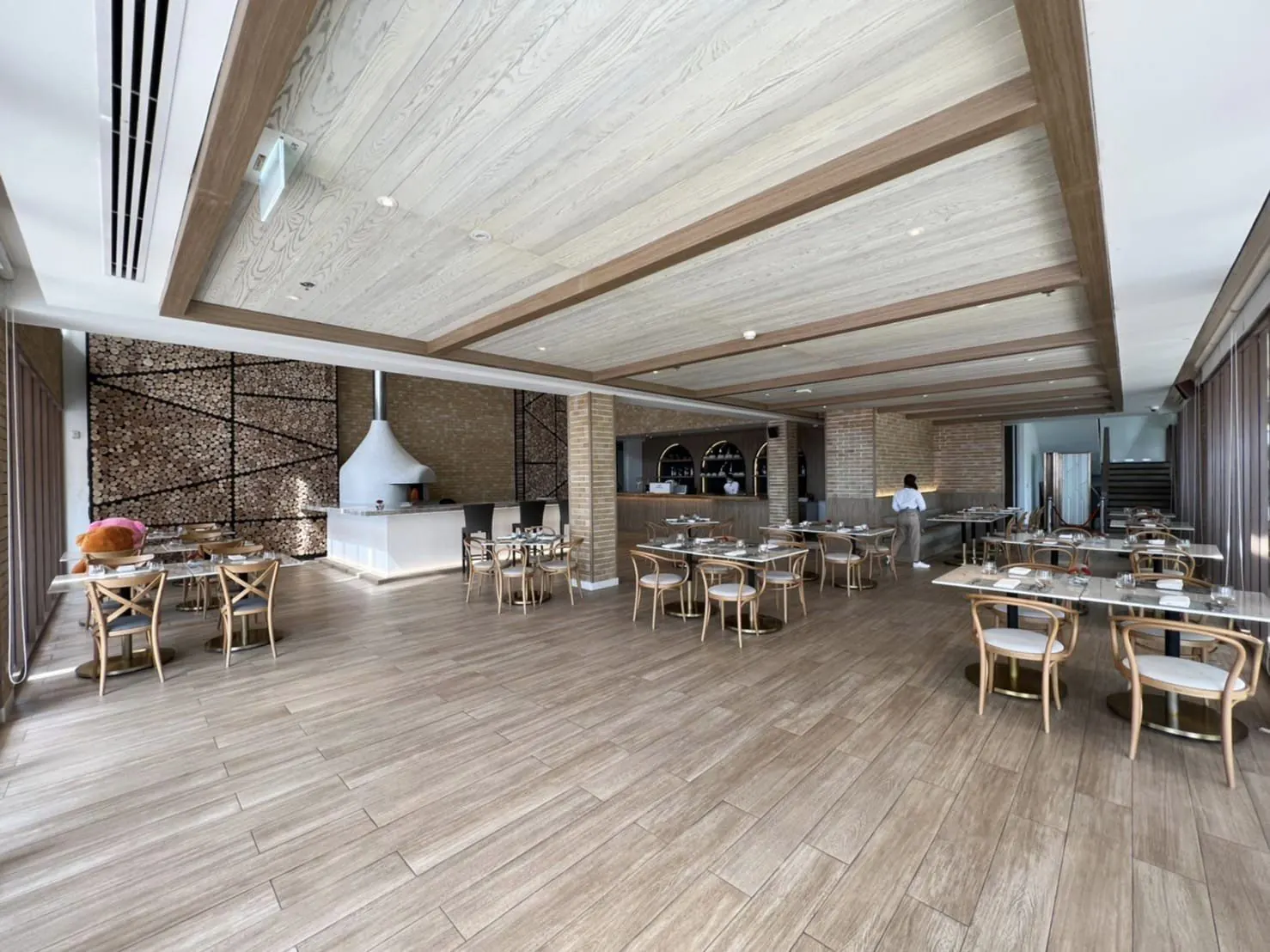 Prego: dining room with loose seating, the bar counter and the white wood-fired oven